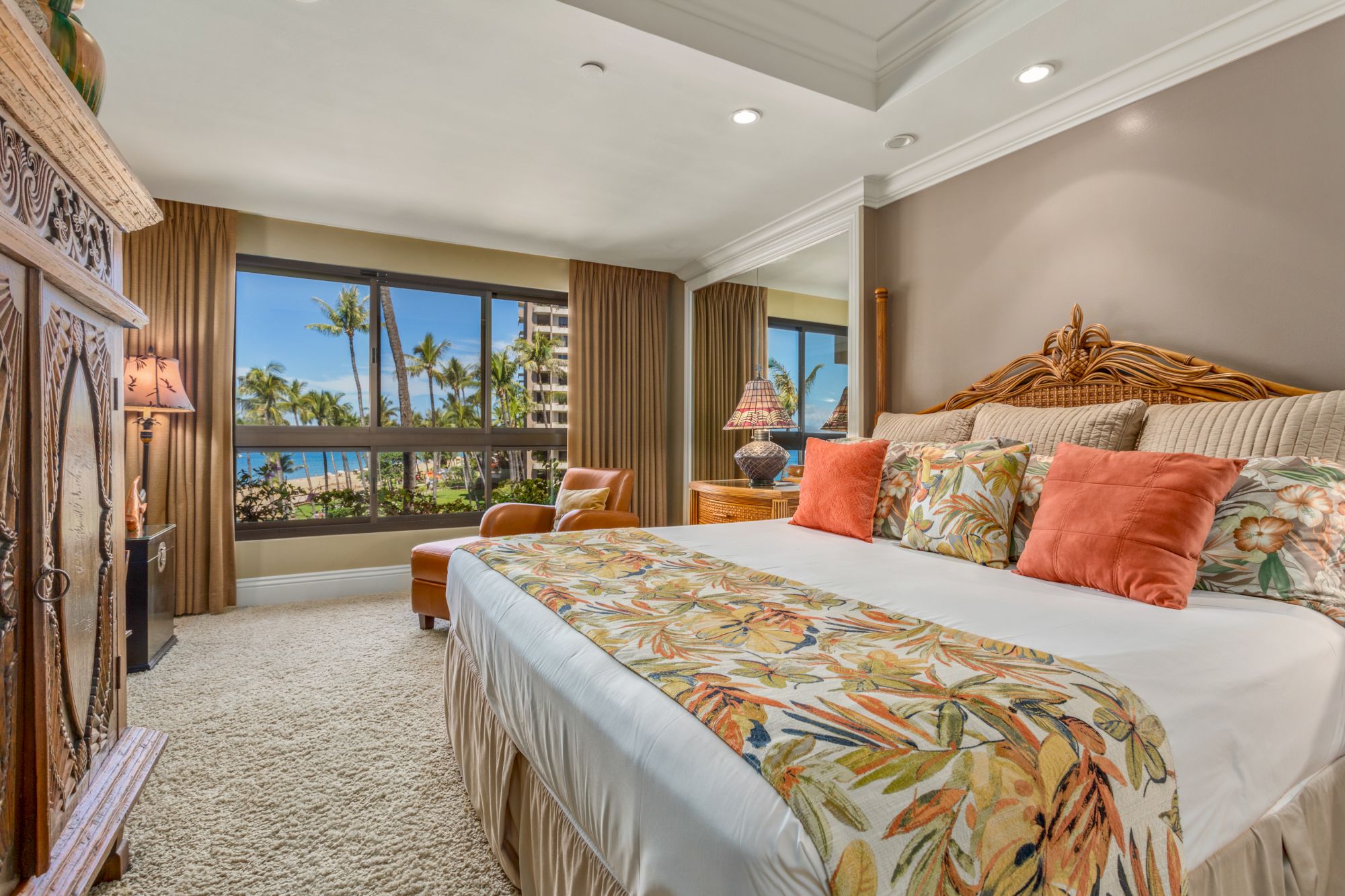 The image shows a tropical-themed bedroom with a large bed, colorful pillows, a window view of palm trees, and cozy decor.