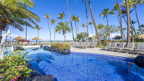 A tropical pool scene with palm trees, lounge chairs, and a vibrant blue sky, creating a relaxing vacation atmosphere.